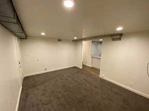 Finished below grade area with recessed lighting, baseboards, visible vents, and dark carpet