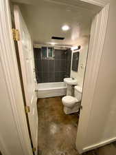 Full bathroom with toilet, recessed lighting, concrete floors, and shower / bathing tub combination
