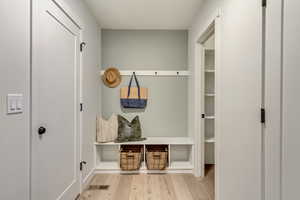Mudroom featuring visible vents and wood finished floors