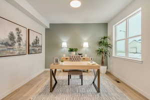 Home office with hardwood laminate floors.