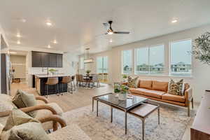 Great room with hardwood laminate flooring, ceiling fan, and recessed lighting
