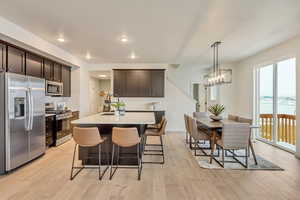 Kitchen with backsplash, light countertops, stainless steel appliances, and hard wood laminate floors