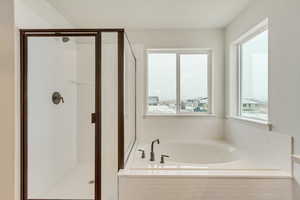 Primary Bathroom featuring a seperate shower and tub