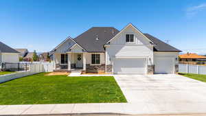 View of front of home featuring board and batten siding, roof with shingles, fence, and a front yard