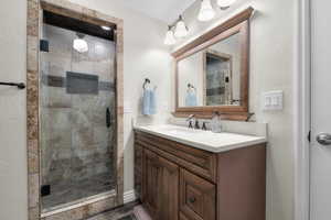 Full bath featuring vanity and a shower stall
