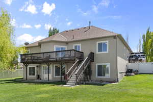 Back of house featuring a deck, a fenced backyard, stairs, and stucco siding