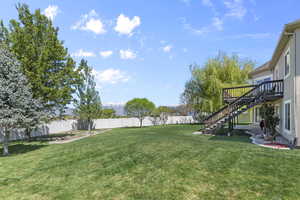View of yard featuring stairway, a deck, and a fenced backyard