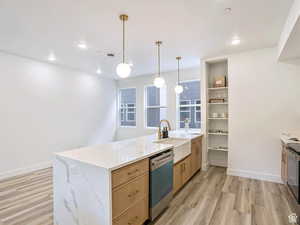 Kitchen featuring a peninsula, light brown cabinets, a sink, light wood-style flooring, and dishwasher