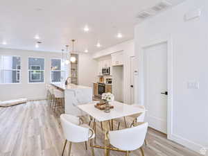 Dining area with recessed lighting, baseboards, light wood-type flooring, and visible vents