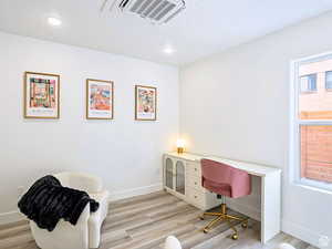 Home office with recessed lighting, baseboards, light wood finished floors, and visible vents