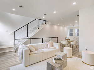 Living area with stairs, recessed lighting, baseboards, and visible vents