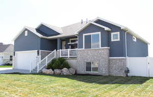 Rear view of property featuring brick siding, driveway, covered porch, and stucco siding