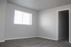 Unfurnished room with carpet flooring and baseboards