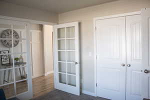 Unfurnished bedroom with a closet, baseboards, and french doors