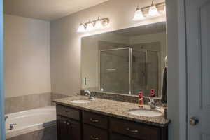 Bathroom with a garden tub, a shower stall, and double vanity