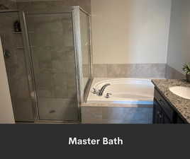 Bathroom featuring a garden tub, a stall shower, and vanity