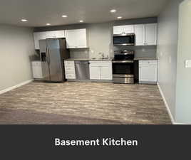 Kitchen with stainless steel appliances, wood finished floors, a sink, baseboards, and recessed lighting
