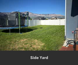 View of yard featuring a trampoline and a mountain view