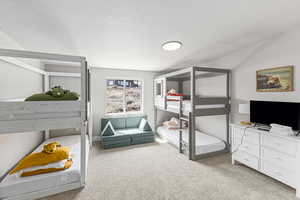 Bedroom featuring a textured ceiling and light carpet