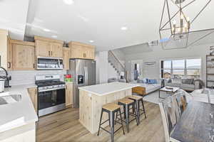 Kitchen with recessed lighting, light wood-style floors, appliances with stainless steel finishes, and light brown cabinets
