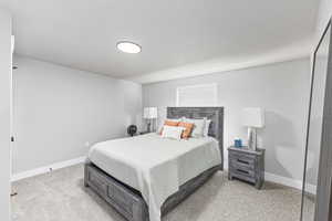 Bedroom featuring carpet floors and baseboards