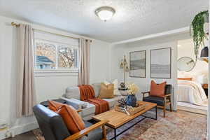 Living room with wood finished floors and a textured ceiling