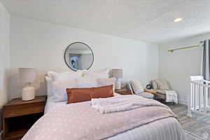 Bedroom featuring recessed lighting, wood finished floors, a textured ceiling, and baseboards