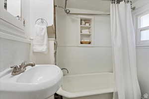 Full bath featuring shower / bath combination with curtain and a sink