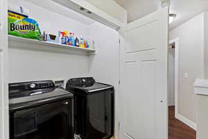 Laundry room with wood finished floors, independent washer and dryer, laundry area, and baseboards