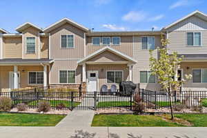 View of front facade with board and batten siding and a fenced front yard