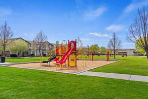 Community jungle gym with a residential view and a lawn