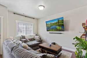 Living room with visible vents, dark wood finished floors, and baseboards