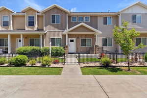 Townhome / multi-family property with board and batten siding and a fenced front yard