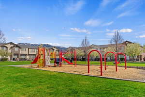 Community playground featuring a mountain view and a yard