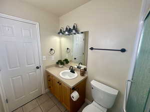 Bathroom featuring toilet, tile patterned flooring, and vanity
