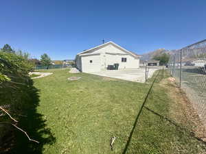 View of yard featuring a fenced backyard, a mountain view, central AC unit, a patio, and a fire pit