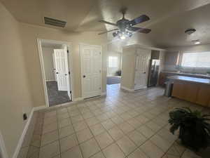 Kitchen with visible vents, ceiling fan, light tile patterned flooring, and stainless steel fridge with ice dispenser