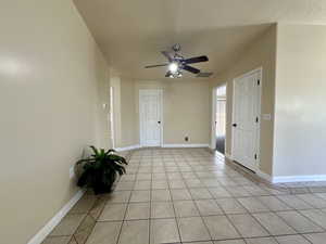 Unfurnished room featuring visible vents, a ceiling fan, baseboards, and light tile patterned flooring