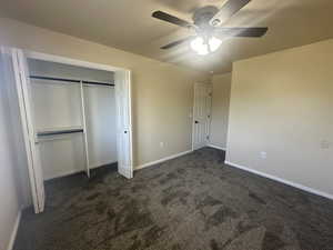 Unfurnished bedroom with baseboards, carpet, ceiling fan, and a closet