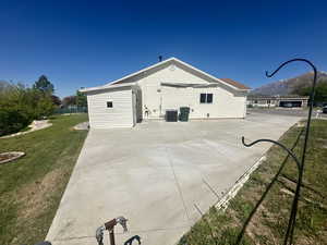 View of side of home featuring a yard, a patio, cooling unit, and a mountain view