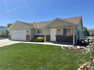 View of front of home featuring roof with shingles, fence, a garage, and brick siding