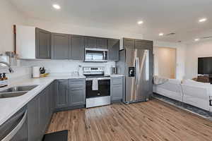 Basement apartment kitchen featuring visible vents, a sink, stainless steel appliances, recessed lighting, and light wood-style flooring