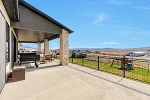 View of patio / terrace with fence, a mountain view, and playground community