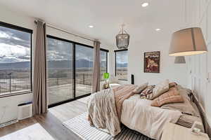 Primary suite featuring access to outside, recessed lighting, wood finished floors, and visible vents