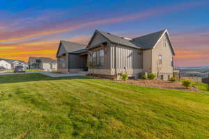 View of side of home with a lawn, central AC, fence, and a shingled roof