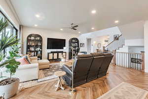 Living room with recessed lighting, ceiling fan, and stairway