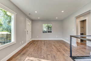 Empty room featuring dark wood-style flooring, baseboards, recessed lighting, and visible vents