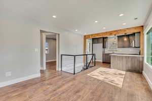 Kitchen featuring recessed lighting, light countertops, baseboards, and wood finished floors