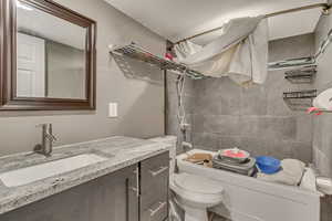 Bathroom featuring vanity, shower / bathing tub combination, and toilet-items have been removed from tub