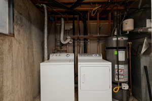 Laundry room with laundry area, water heater, and washer and dryer